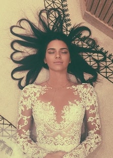 Kendall Jenner lying on the floor with her hairs being shaped as hearts