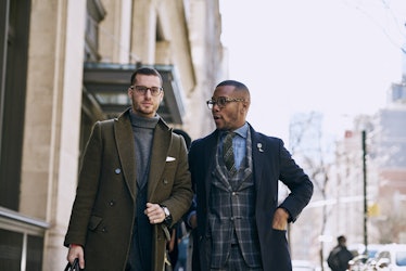 Two guys walking down a street in shirts and blazers 