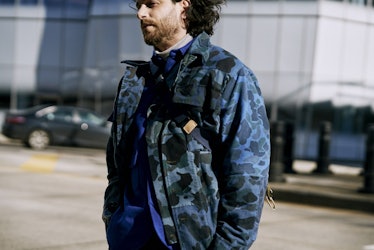 A man wearing a black and blue army jacket