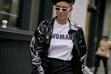 A woman walking in a black leather jacket and white shirt