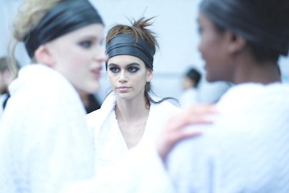 Kaia Gerber and two other models backstage at a Tom Ford show in white robes 