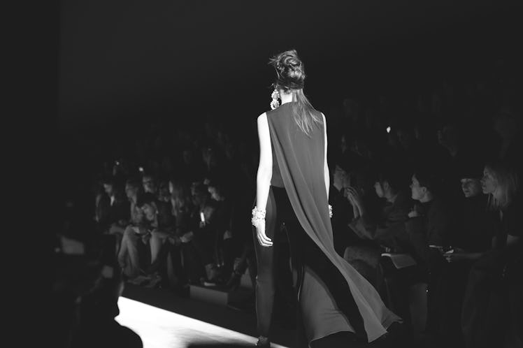 A model walking in a black gown down a runway at the Tom Ford Fall 2018 show