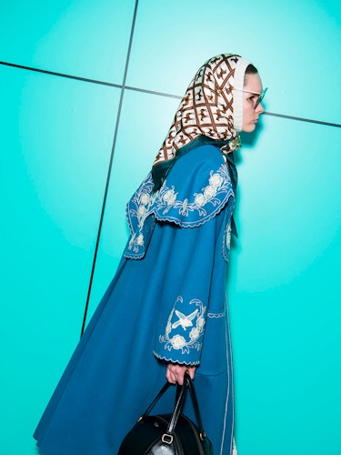 A model wearing headscarf, sunglasses and a blue embroidered coat at the Gucci Fall 2018 runway show