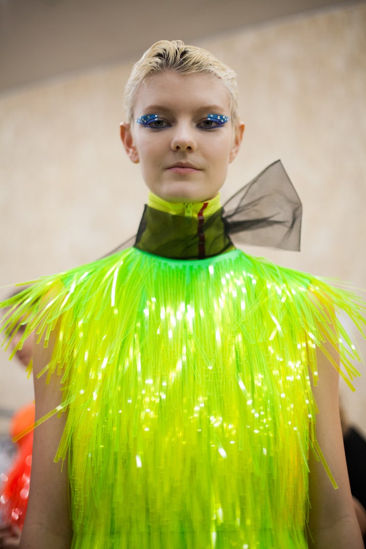 A model wearing a neon fringed top at the Prada Fall 2018 show during Milan Fashion Week