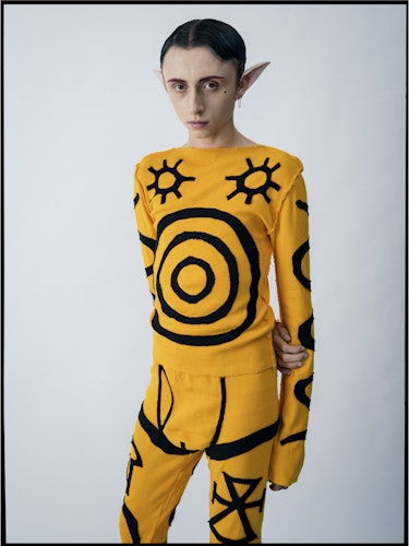 Lucas Nettleton-Tate in a yellow and black outfit with sun print by Charles Jeffrey