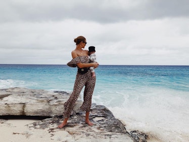 Mom supermodel Rosie Huntington-Whiteley on rocky beach holding her son Jack Oscar.