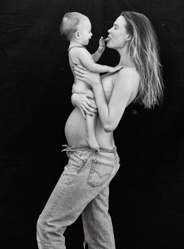 Pregnant mom supermodel Behati Prinsloo topless holding daughter topless.