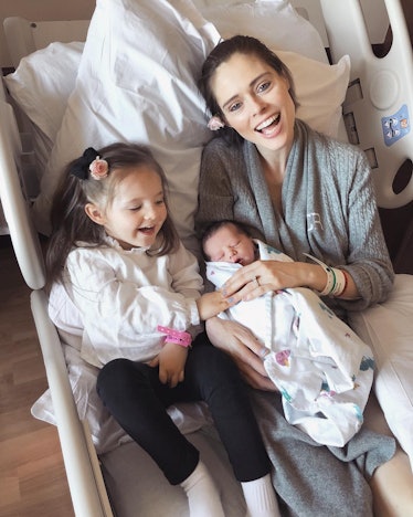 Coco Rocha, mom and supermodel, smiling and laying in hospital with her daughter and newborn son.