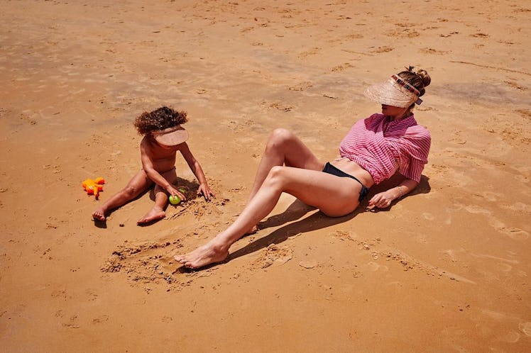 Mom supermodel Doutzen Kroes sunbathing on sand beach with her daughter Myllena.