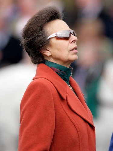 Princess Anne wearing a red coat and athletic sunglasses