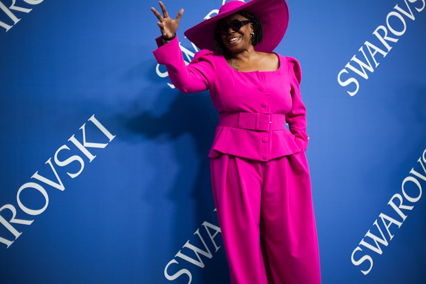 Whoopi Goldberg in a pink blazer, pants, and hat combination