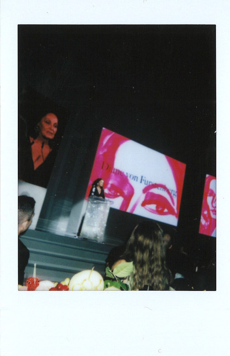 Diane Von Furstenberg giving a speech while her face is displayed on a large screen