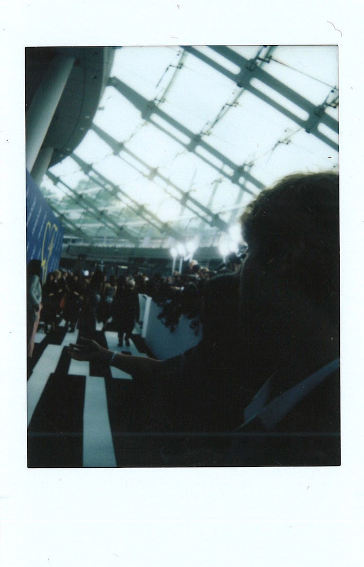 A large crowd moving through a hall with a dark color filter