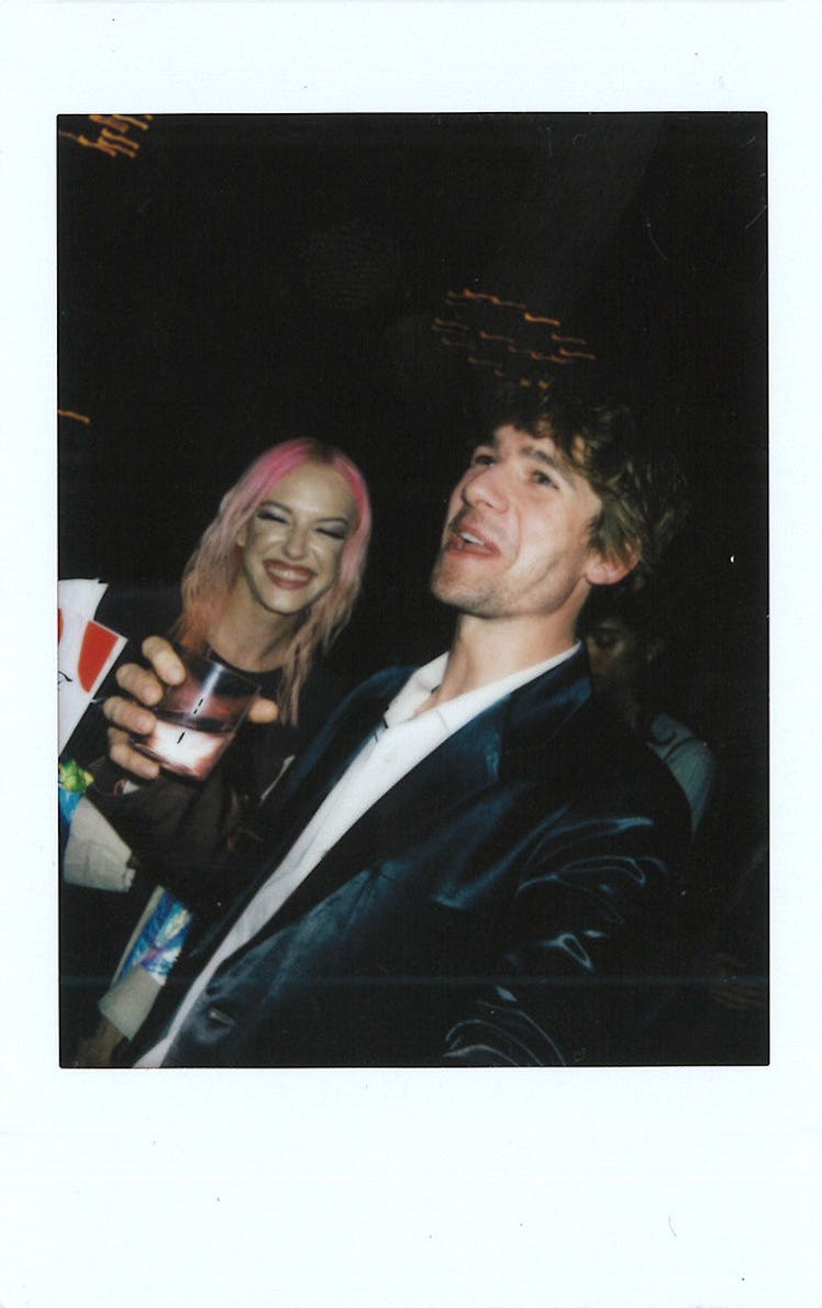 Sander Lak in a white shirt and black blazer and Bria Vinaite in a black top smiling