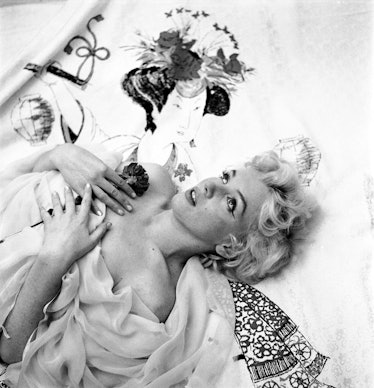 Marilyn Monroe lying down in a dress photographed by Cecil Beaton