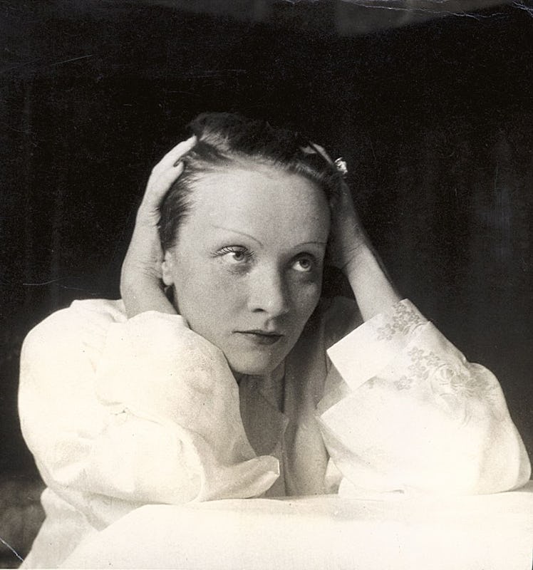 Marlene Dietrich leaning her head against her hands photographed by Cecil Beaton