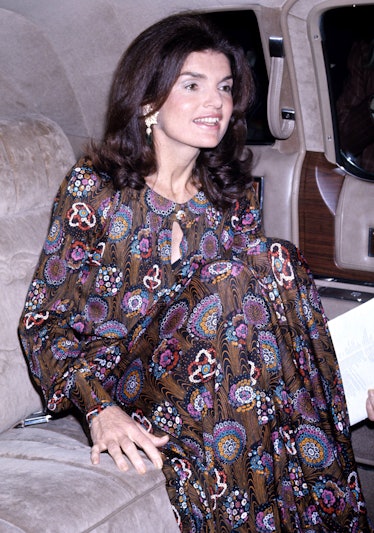 Jackie O in a ‘70s-style printed maxi dress, sporting subtle curls and hanging earrings. 