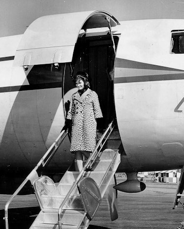 Jackie Kennedy getting off an airplane in a leopard-print coat.