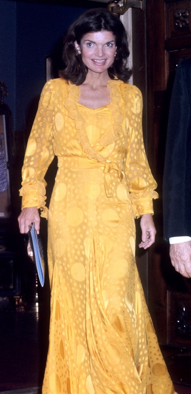 Jackie O  at the Metropolitan Opera House in a long yellow gown.