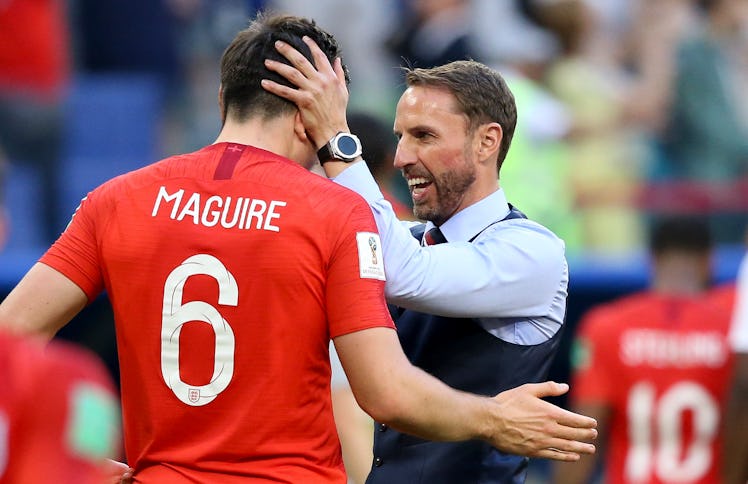 Gareth Southgate in a black waistcoat hugging Harry Maguire after winning the Quarter Final 2018 Wor...