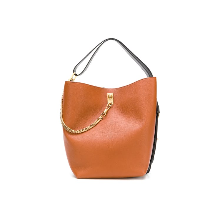 An orange Givenchy bucket bag with a small gold chain