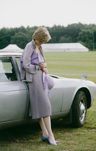 Diana Spencer wearing a lilac ensemble and staring at the ground