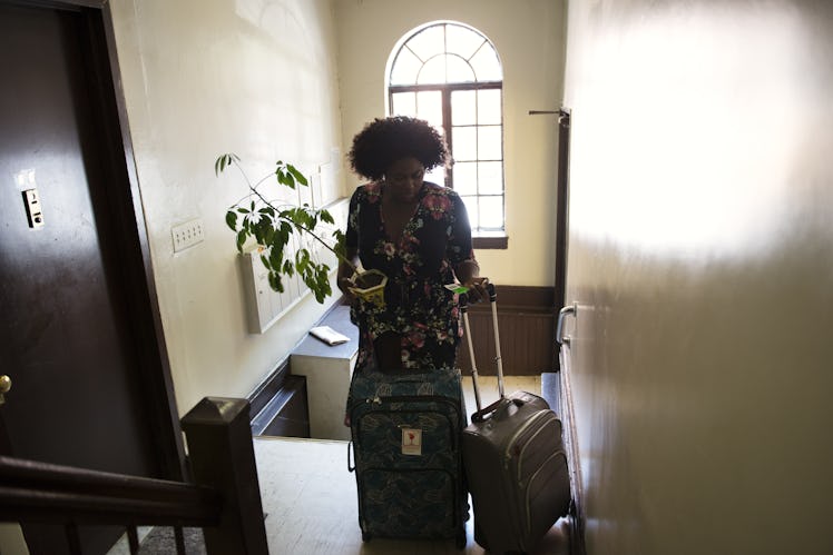 Danielle Brooks entering a flat with two suitcases