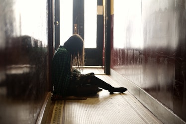 Nina Dobrev sitting and crying on the floor of a hallway