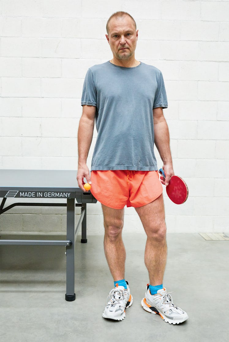 Juergen Teller wearing Balenciaga sneakers while playing table tennis