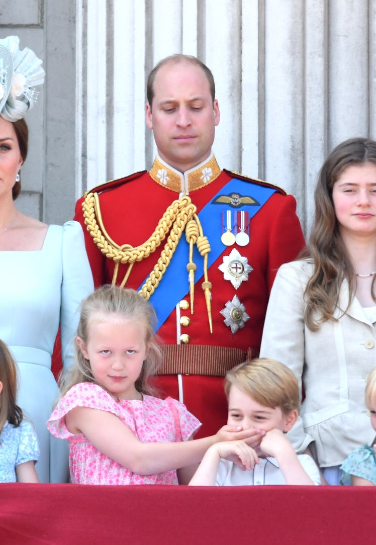 Prince William looking at Savannah Phillips covering Prince George’s mouth on the balcony of Bucking...