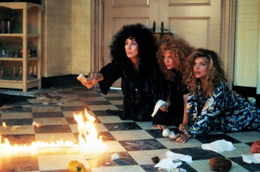 Cher next to two women in front of a fire in 'The Witches of Eastwick'