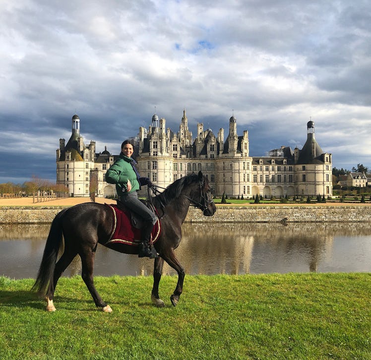 Kendall Jenner riding a horse in front of a castle