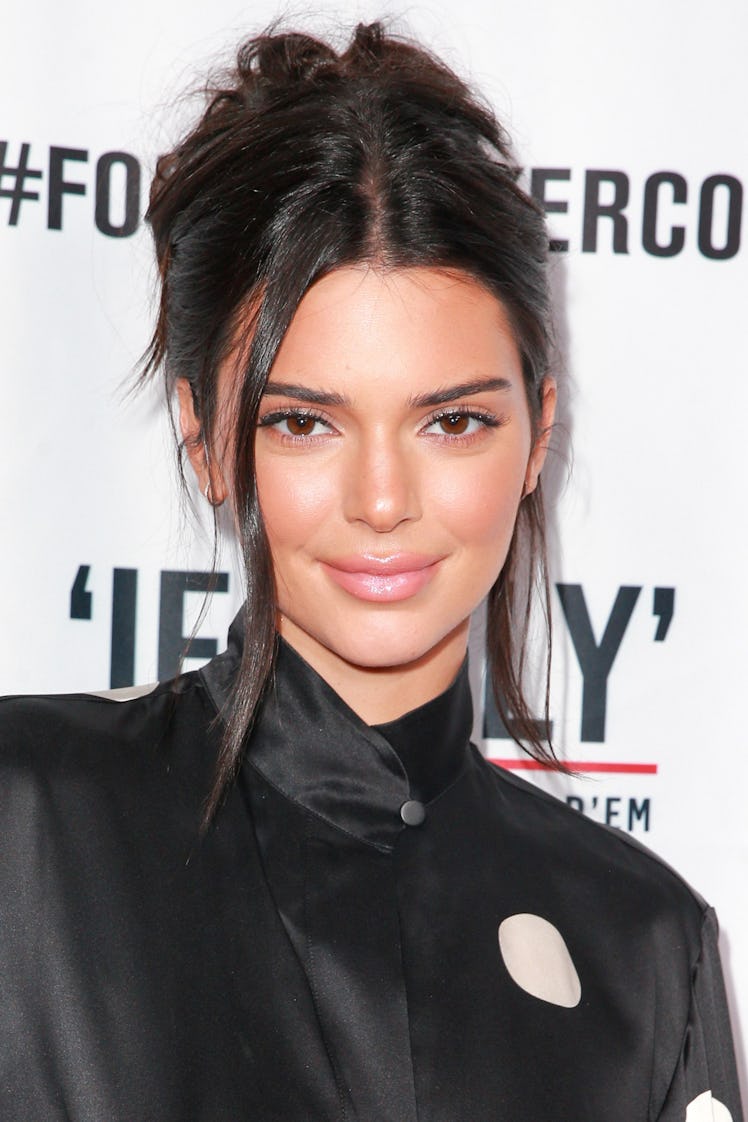 Kendall wearing a sloppy bun and enhances her look with a glossy lip at the red carpet