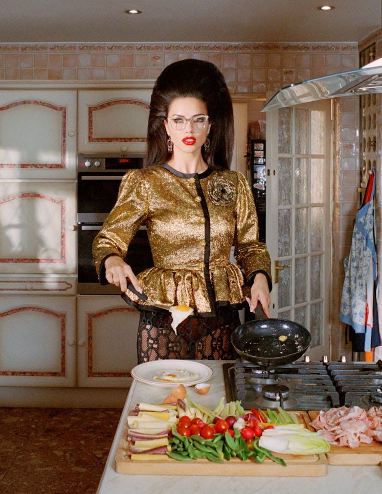 Adriana Lima wearing a golden blazer while cooking