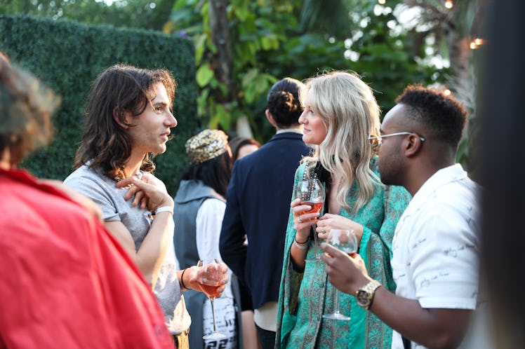 Three guests drinking champagne at the Ruinart x Art Basel Miami Beach champagne event