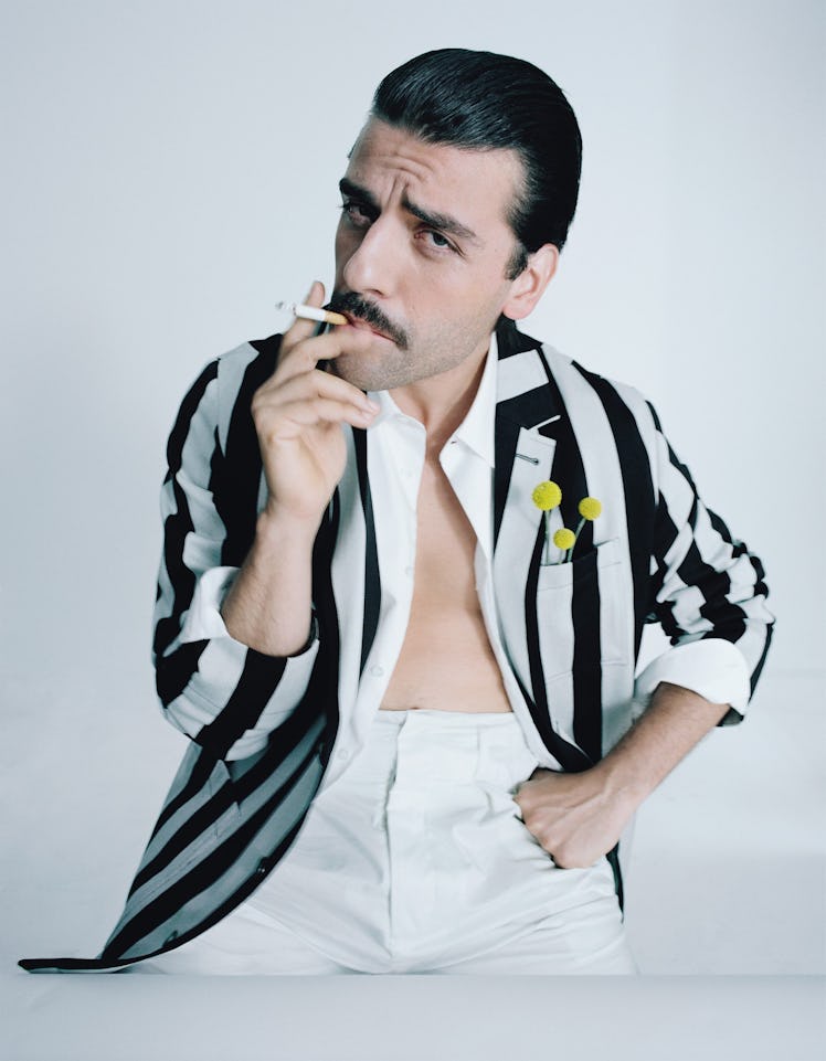Oscar Isaac posing in a white and black striped shirt