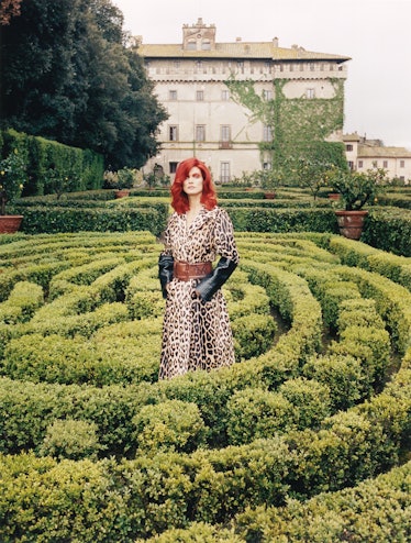 Malgosia Bela posing in a garden while wearing a leopard printed dress