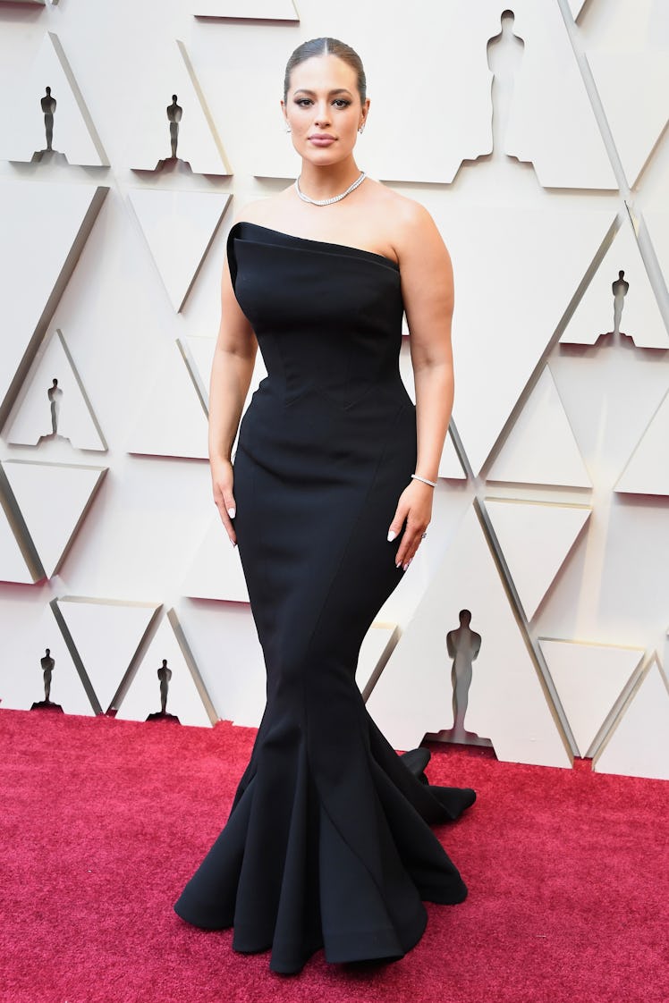 Ashley Graham posing in a black gown while attending the 2019 Oscars Red carpet 