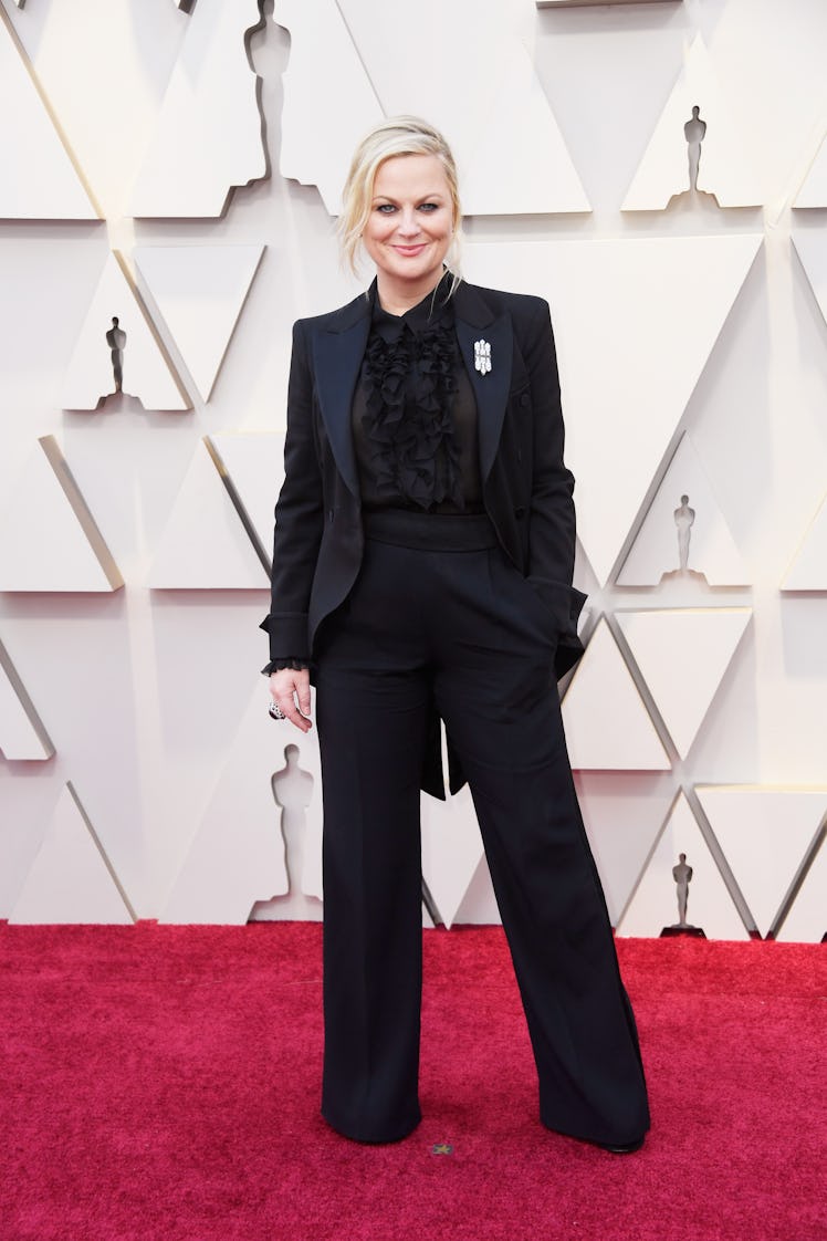 Amy Poehler posing in a black suit at the 2019 Oscars Red carpet 