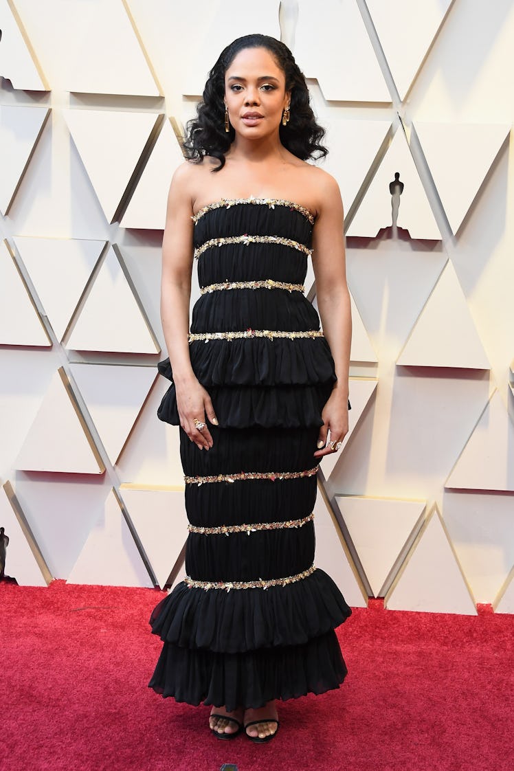 Tessa Thompson in a strapless long black dress with golden stripes while attending the 2019 Oscars R...