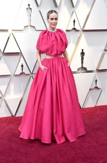 Sarah Paulson wearing a long pink cut-out gown while attending the 2019 Oscars red carpet 