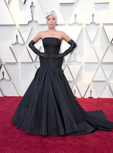 Lady Gaga wearing a long black gown and matching gloves at the 2019 Oscars red carpet