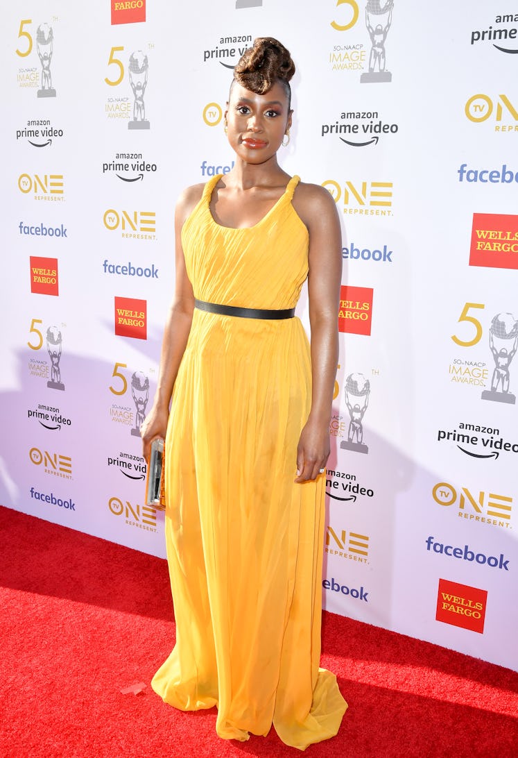 Issa in a yellow gown and her hair up at he NAACP Image Awards in 2019 
