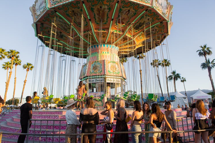 Guests standing next to a carousel at the Revolve Festival in La Quinta, California