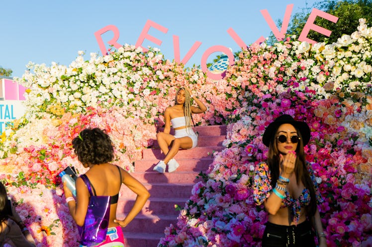 A girl posing for a photo on pink stairs at the Revolve Festival in La Quinta, California