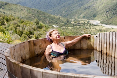 Senior woman relaxing in a wooden hot tub