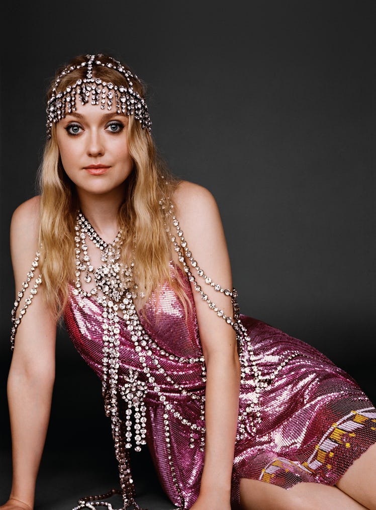 Fanning wears a Gucci dress, headpiece, and body chain.