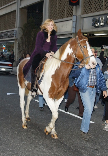 Madonna riding a horse on the street