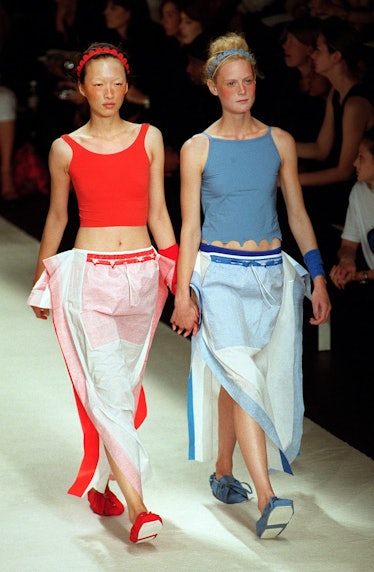 Two models wear red and blue tank tops over white