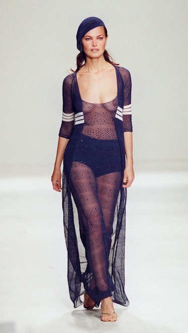 A  model wears a sheer floor-length sweater wrap d